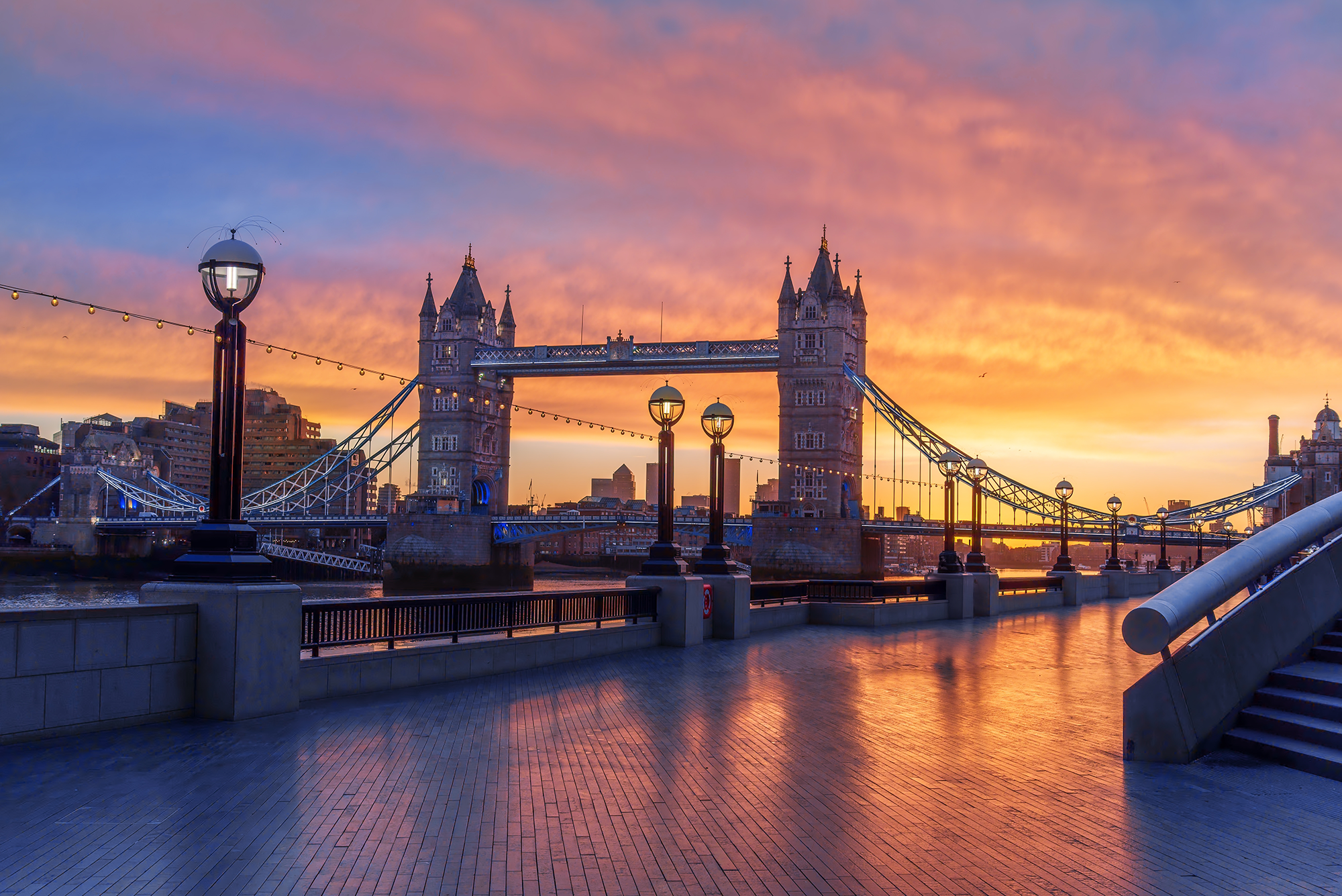 Reistips Londen: Een spectaculaire zonsopgang bij de Tower Bridge gezien vanaf de Theems-promenade.