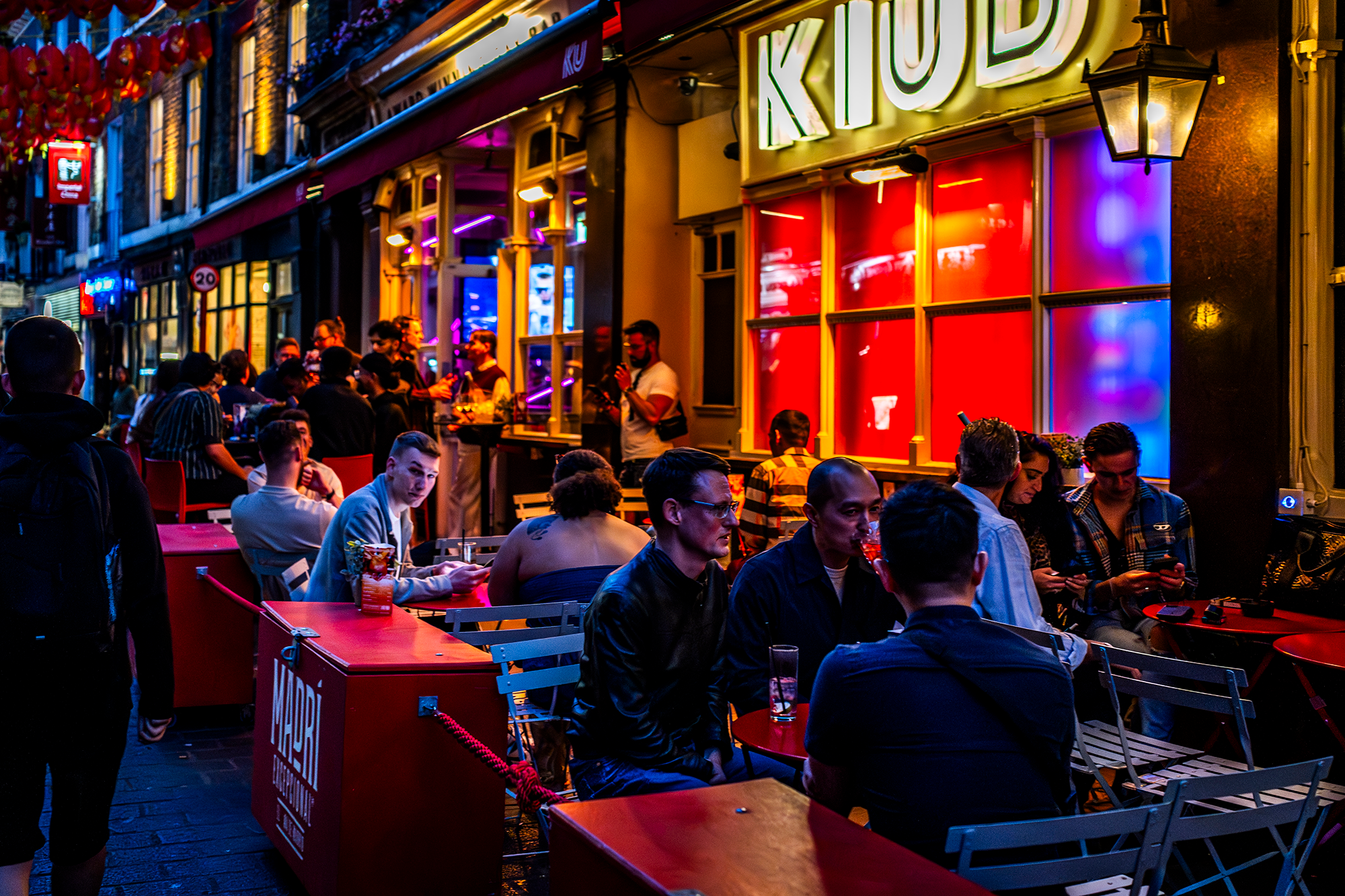 Reistips Londen: Geniet van het nachtleven op een sfeervol terras in Soho.